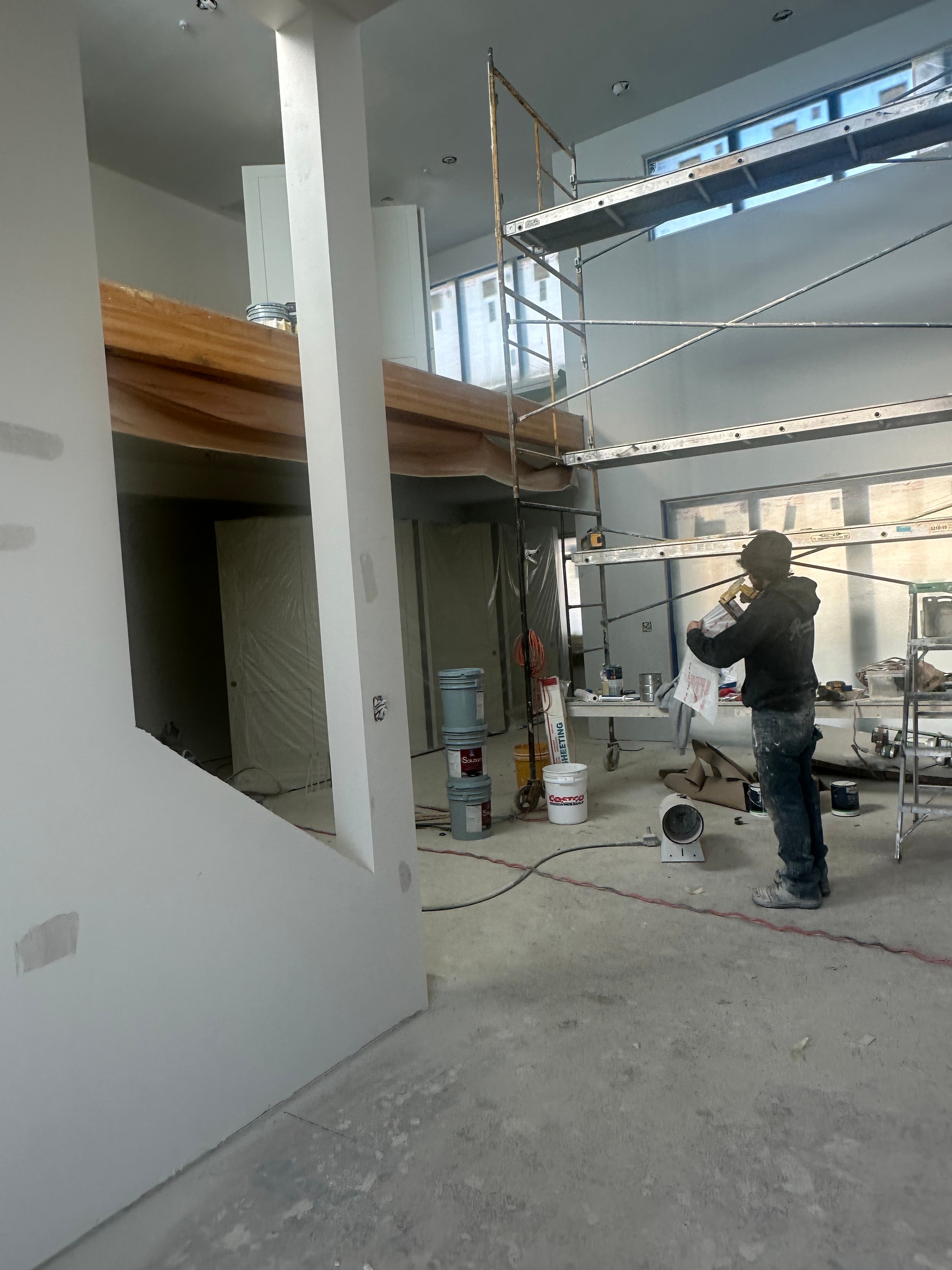 Interior painting in progress with professional scaffolding and spray application