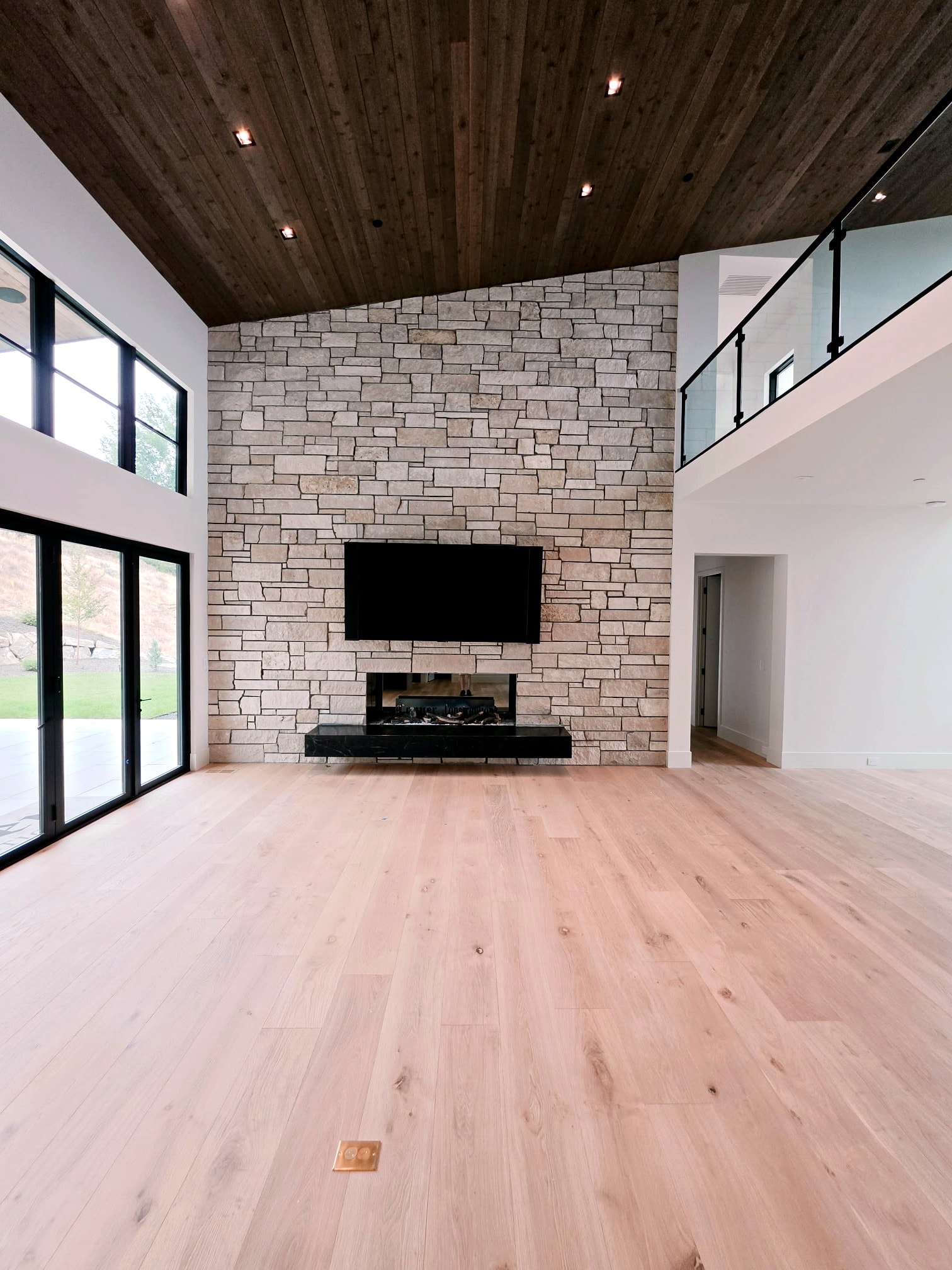 Hillside Haven living room — stone fireplace wall, wood ceiling, and flawlessly painted interior surfaces
