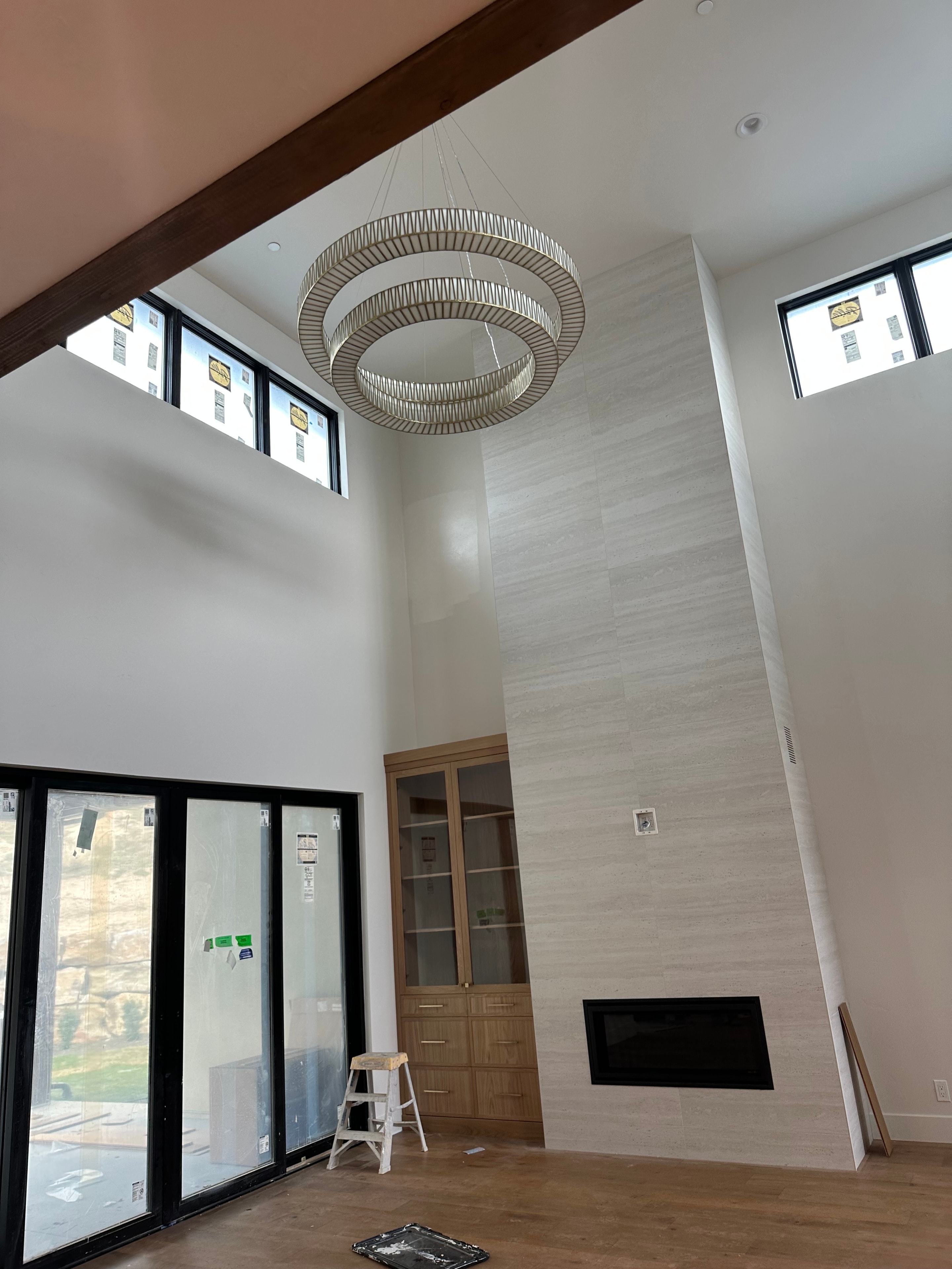 Stunning finished great room with high ceilings, chandelier, and pristine painted walls
